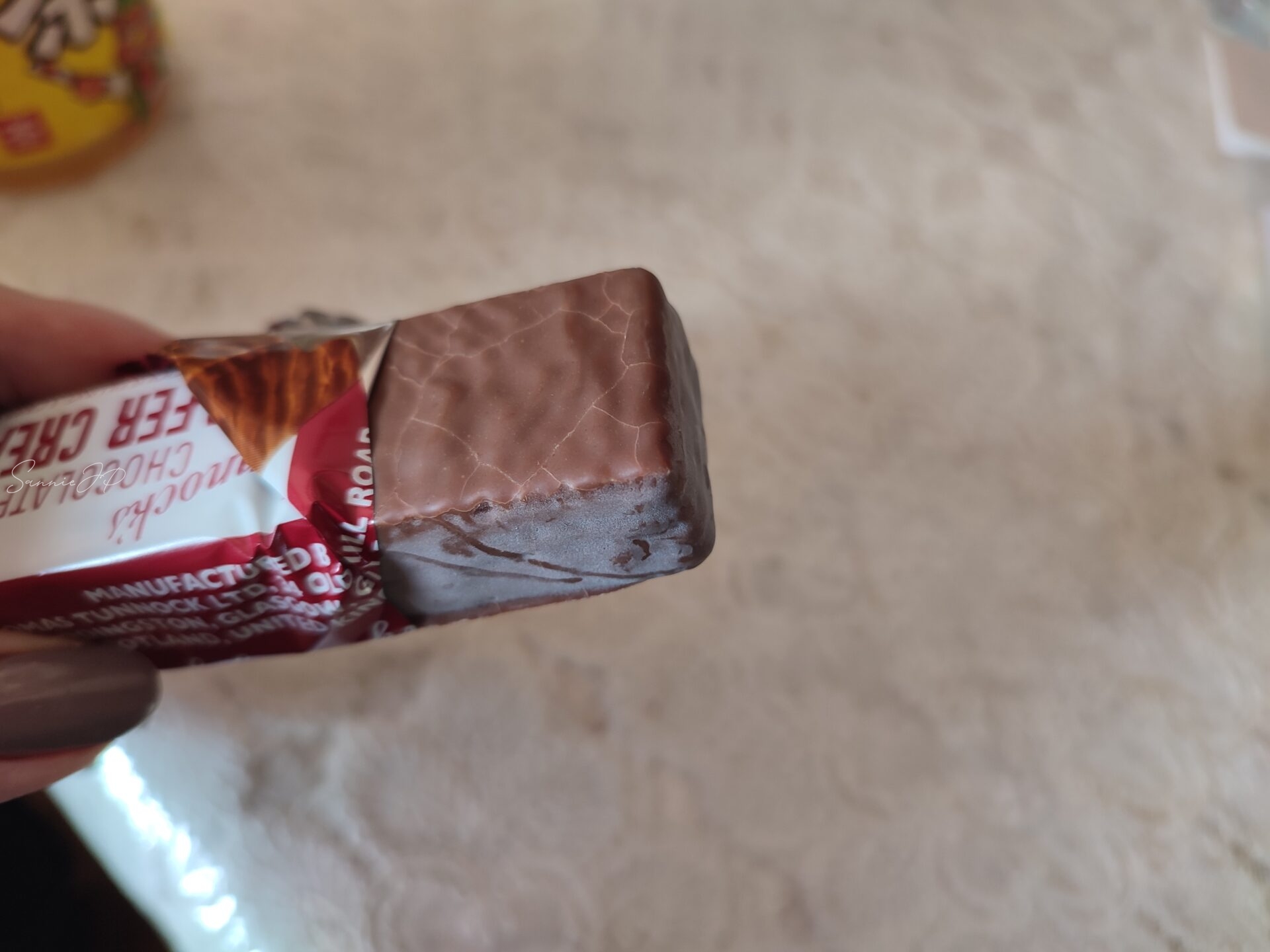 手に持った「ターノック チョコレートワイファー」。少しヒビの入ったチョコの表面もご愛嬌で、懐かしい味への期待が高まる瞬間です。