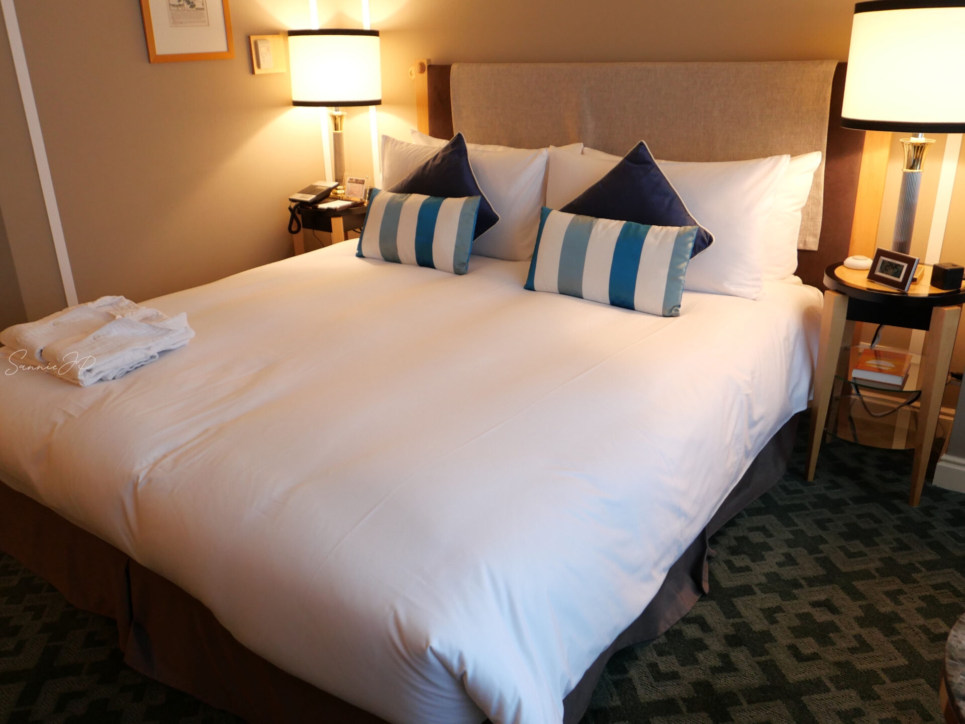 キングサイズのクラシカルダブルベッド。二人でもゆったり寛げる広さで、上質な眠りを叶えてくれる。