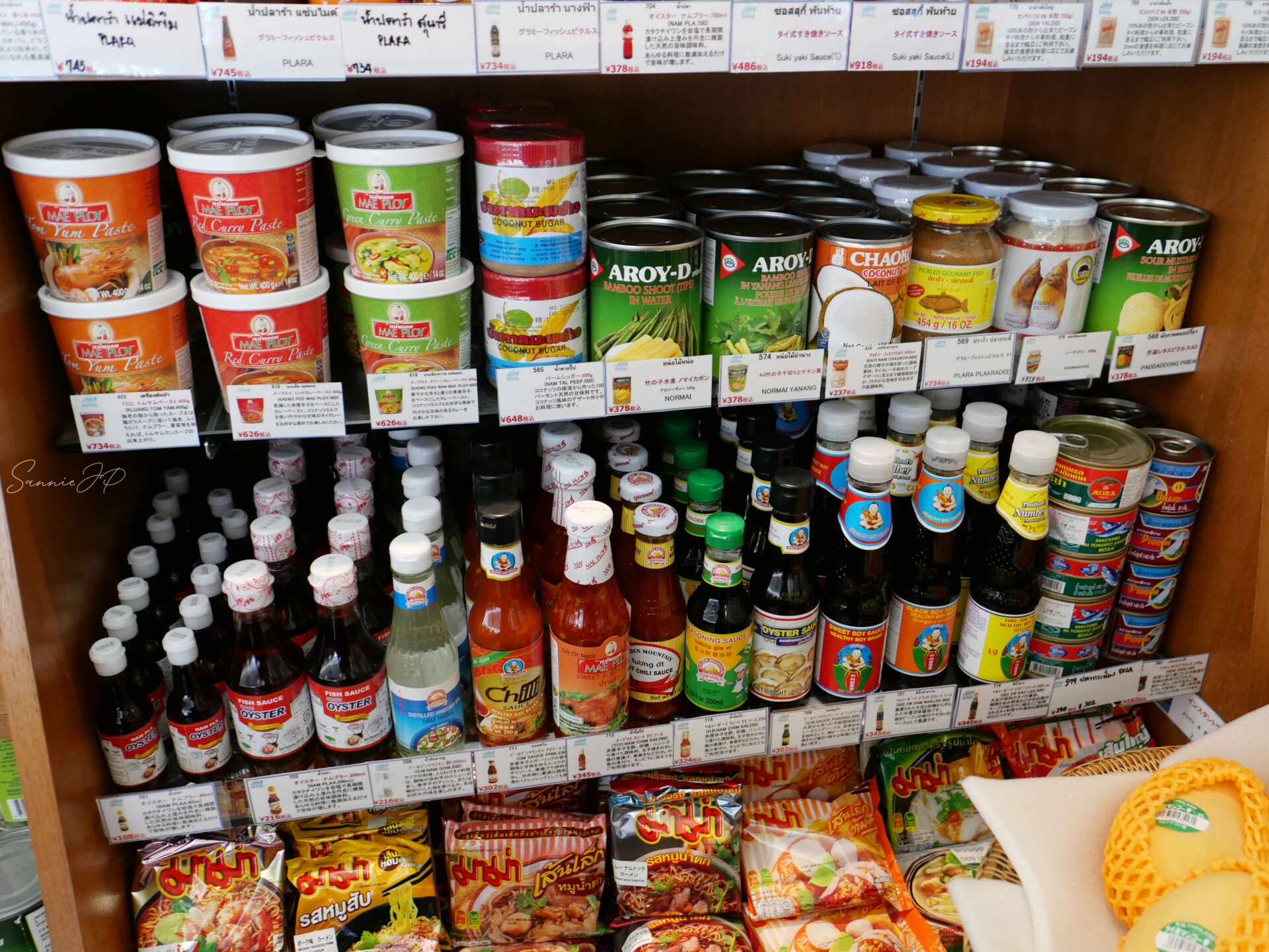 ゲウチャイ 新宿店のレジ周りに並ぶタイ料理向けの缶詰や調味料