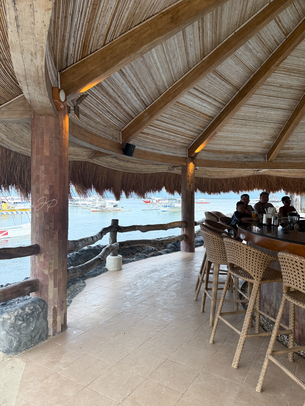 Bluewater Maribago Oyster Barの半円形カウンター席と海辺の店内