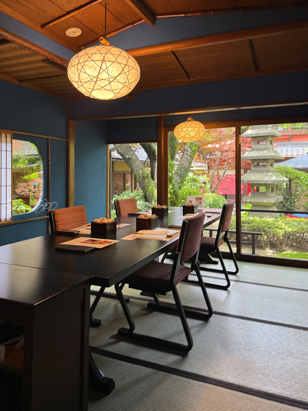 とうふ屋うかい 鷺沼店の個室と、窓越しに見える中庭の景色