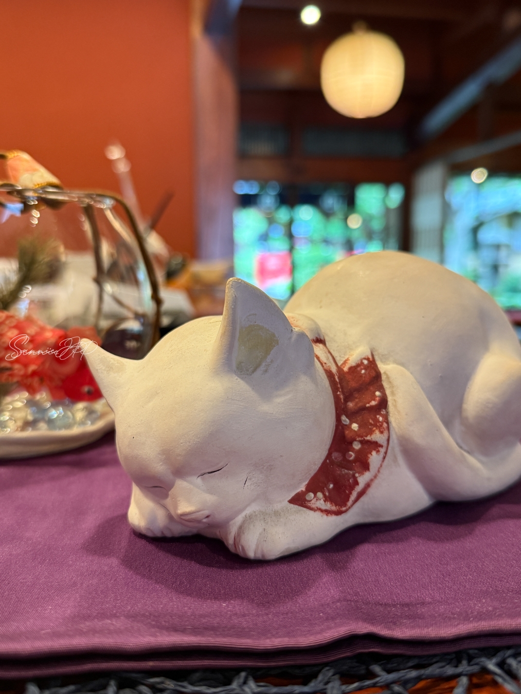 とうふ屋うかい 鷺沼店のレジ横に置かれた眠る猫のオブジェ