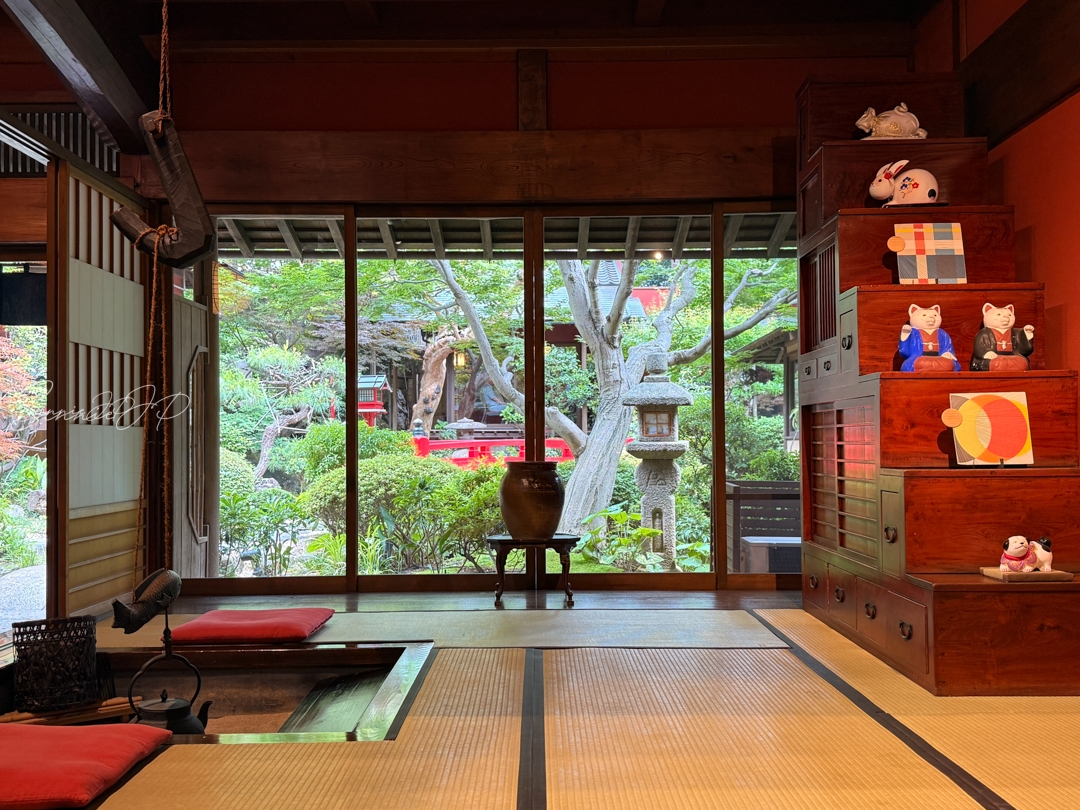 囲炉裏のある和室と、大きな窓越しに見える日本庭園