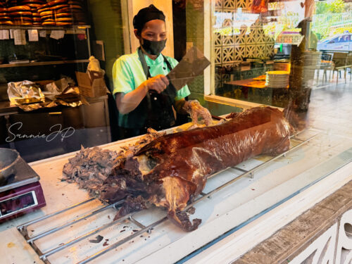 House of Lechon Acacia Street店のレチョンを切り分ける様子
