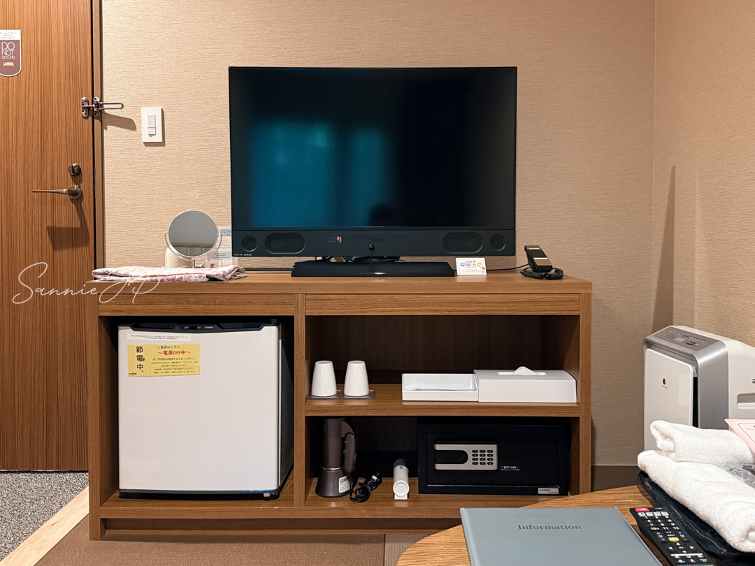 テレビと、その下に整然と配置された設備類。箱根ゆとわ客室の機能的なレイアウト