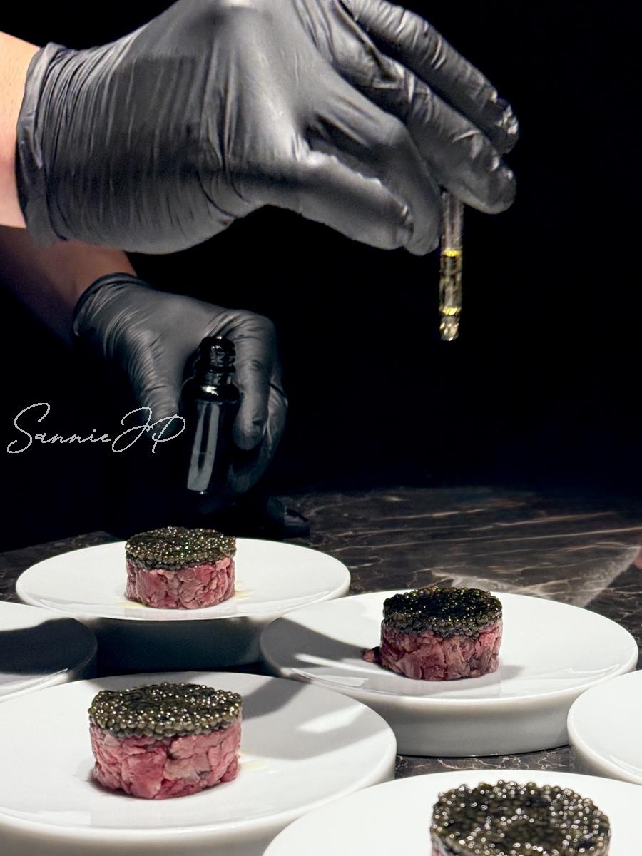 燻製オリーブオイルをキャビアに垂らす瞬間。香りがふわりと広がり、新進気鋭らしい洗練された演出が際立つ。