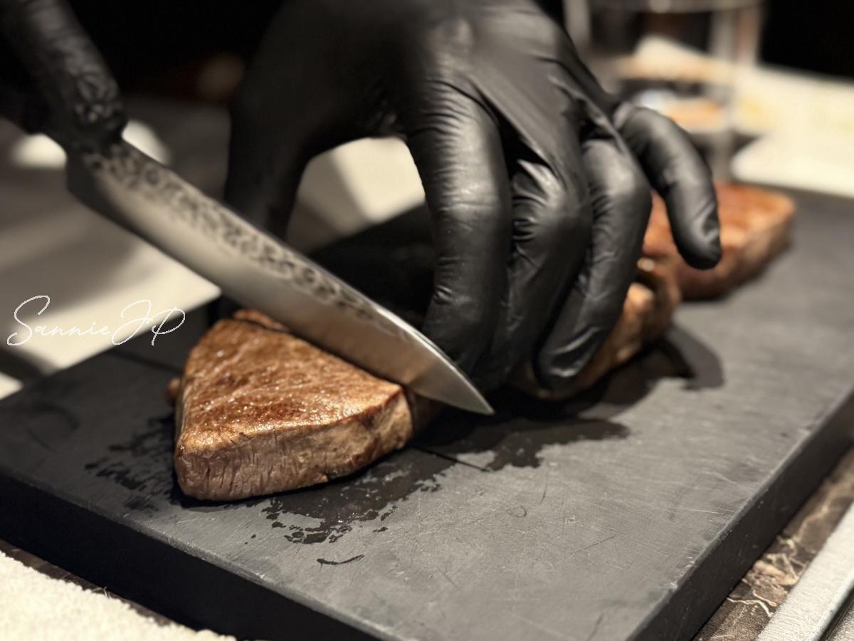 焼き上がったお肉をカットする瞬間。肉汁がきらりと光り、新進気鋭の焼肉の美味しさが伝わる迫力ある一枚。