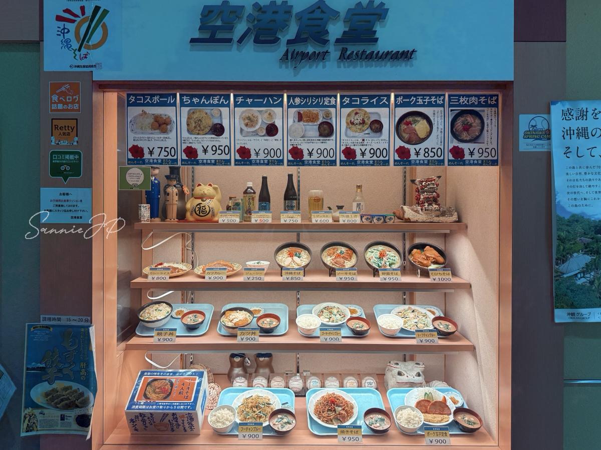 那覇空港の空港食堂店頭に並ぶメニューサンプル全体で、沖縄料理の種類が分かりやすく安心感がある