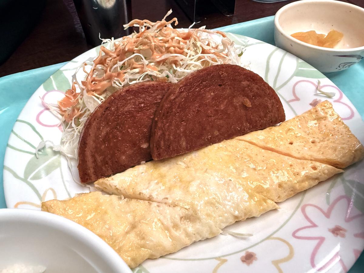 那覇空港の空港食堂で食べたポーク玉子定食のアップで、沖縄らしい素朴な組み合わせが伝わる写真