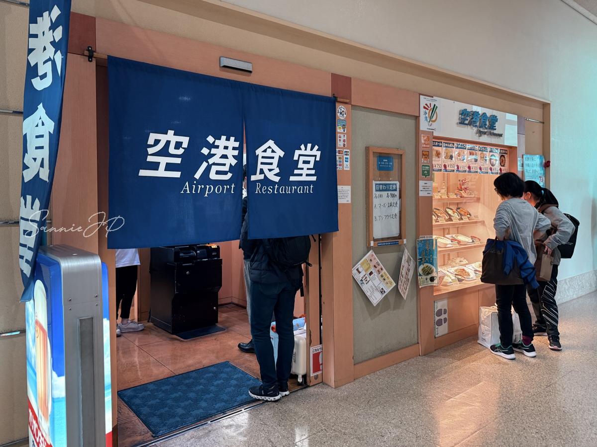 那覇空港の空港食堂の入口とのれんを写した写真で、気取らない食堂らしい雰囲気が感じられる一枚