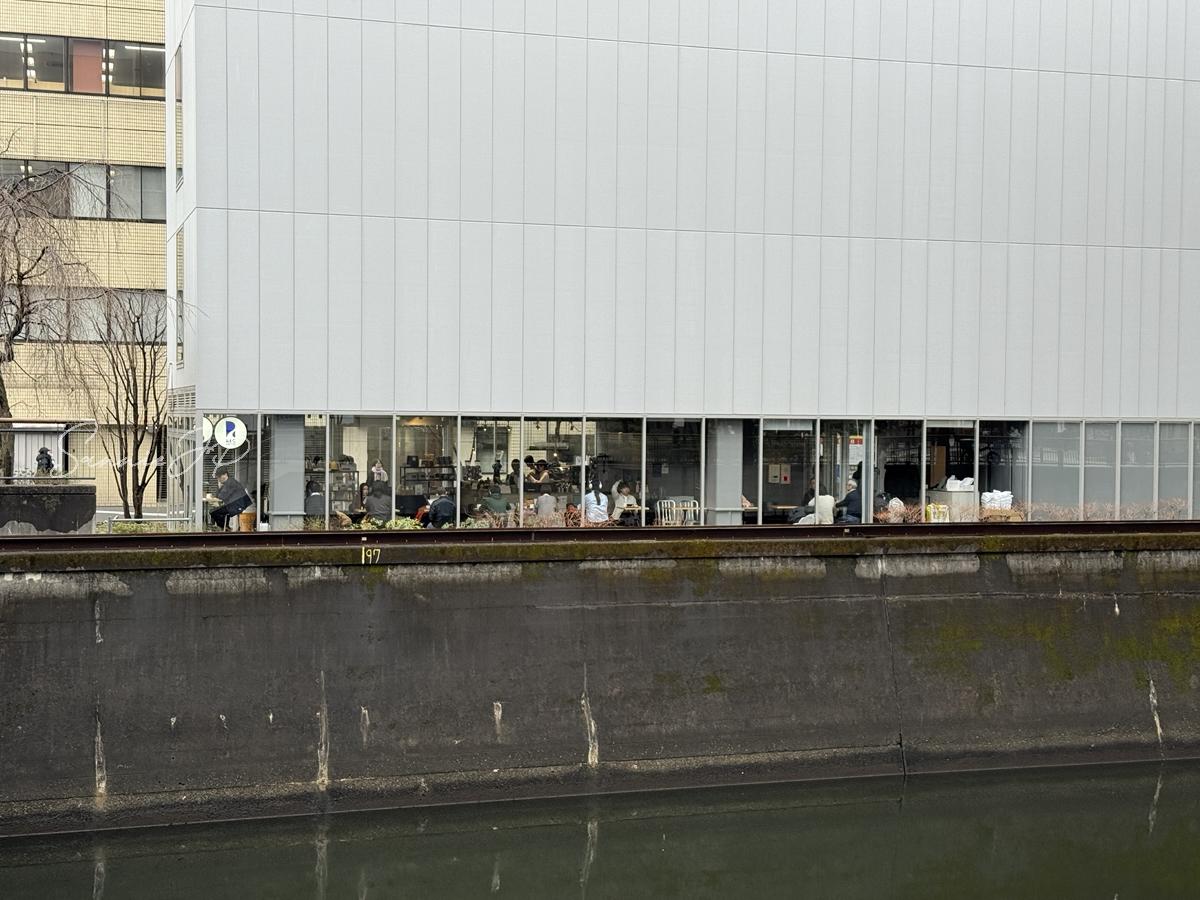 水道橋のREC COFFEE 水道橋店を対岸側から見た外観。混雑前に寄りたい落ち着いた立地